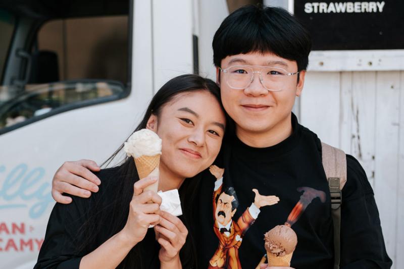 Two students standing in front of an ice cream van.