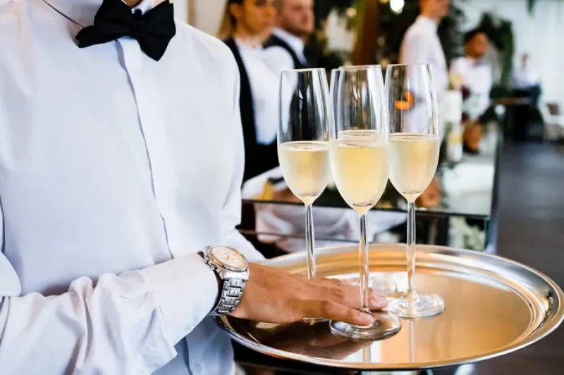 A server carries a tray of champagne