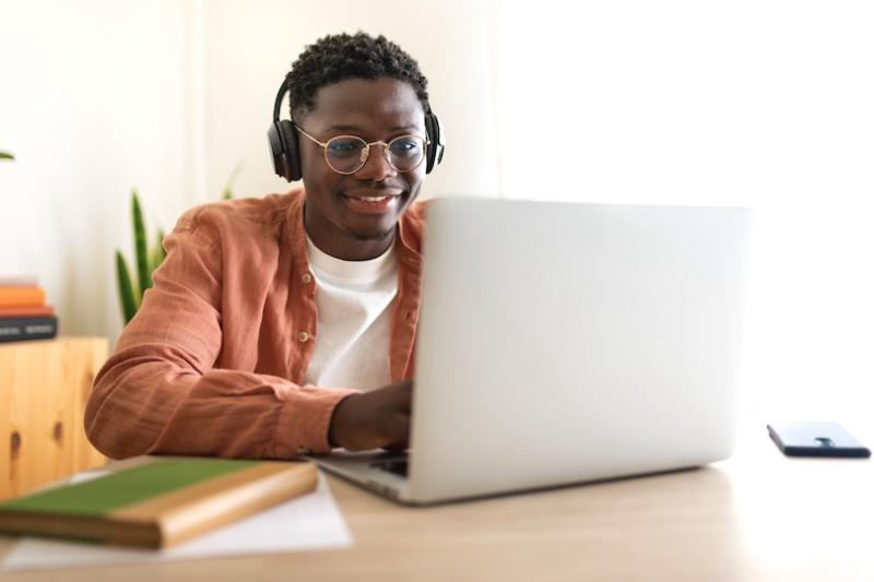 Student looks happy and confident with laptop