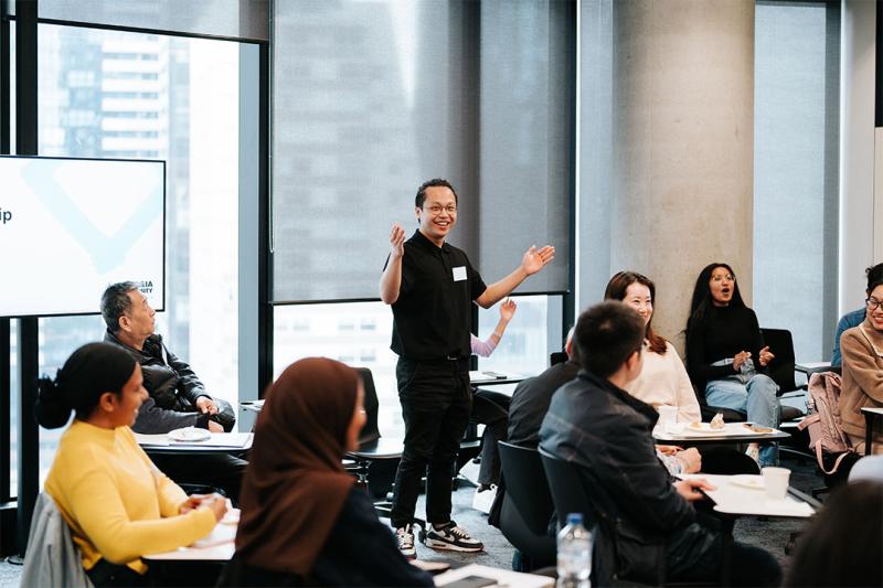 A facilitator stands in a classroom at VU's City campus, leading a workshop.