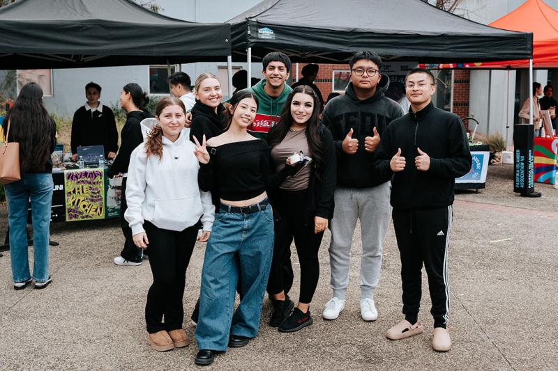 Seven students post in front of stalls at St Albans Ofest.
