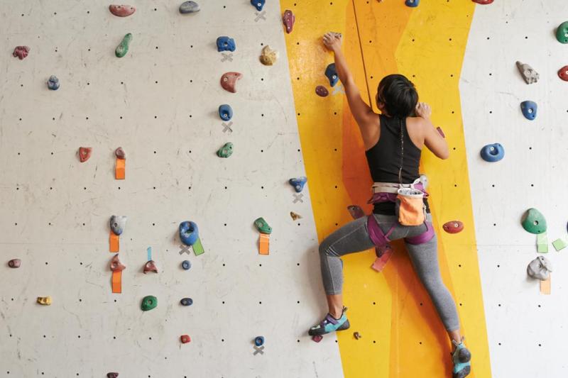 A person climbing an indoor rock climbing wall.