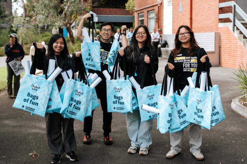 a group of students with VU blue tote bags in campus courtyard