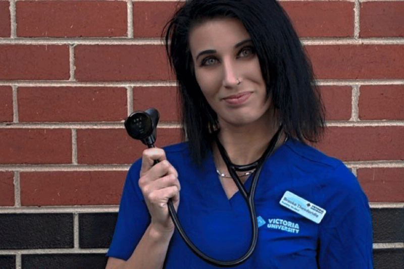 Young woman in a Victoria University nursing uniform and sethoscope, with 