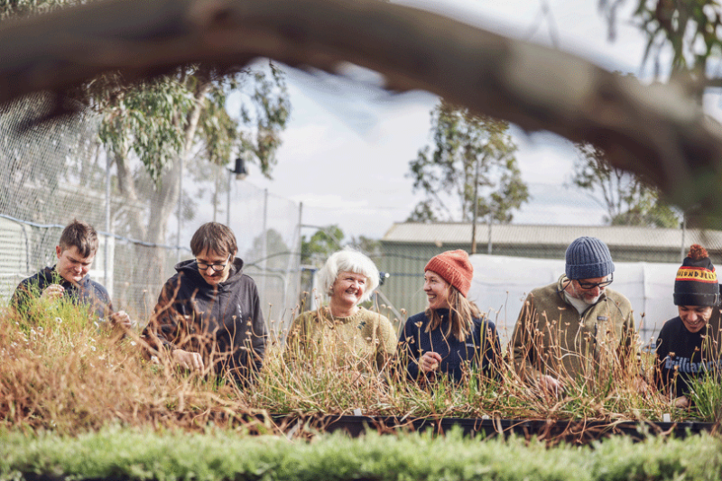 A group of volunteers working together potting seedlings at Iramoo Nursery, alongside Megan O'Shea (centre) 