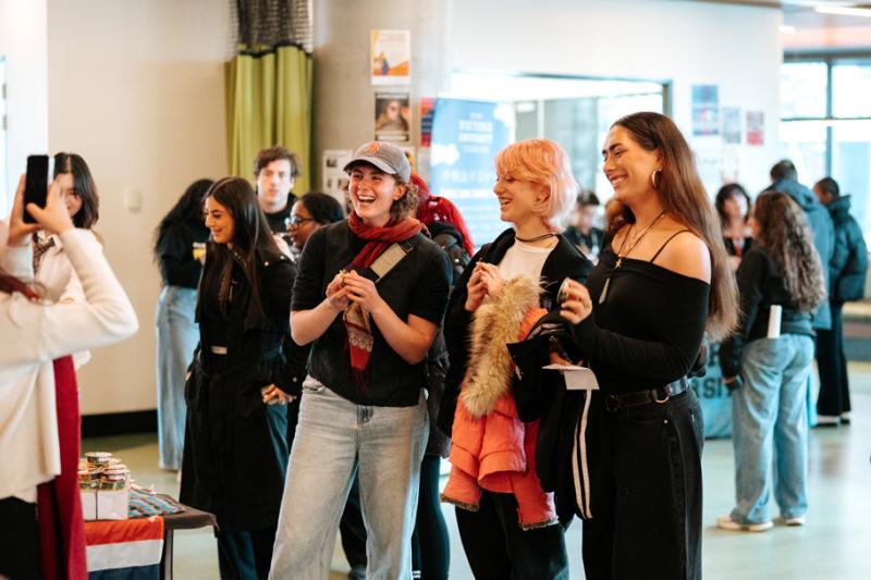 A group of happy, relaxed students at a casual event in a modern building