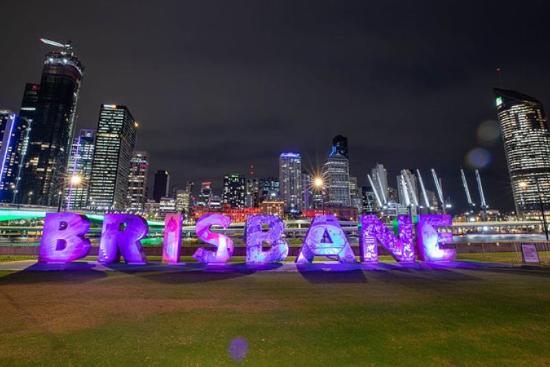 Illuminated 'Brisbane' sign at night.