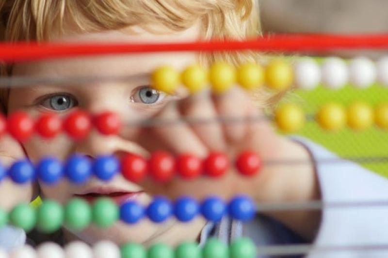 A child plays with an abacus.