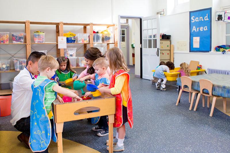  Children and teachers in preschool classroom.