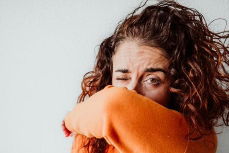 Someone coughing into their elbow. 