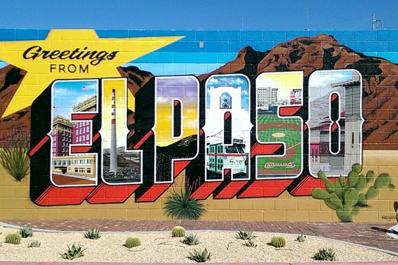A colourful sign saying Greetings from El Paso, with mountains in the background and blue sky