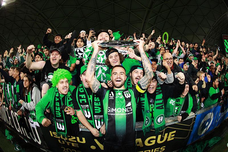  VU student Josh Risdon holds the A-League trophy and celebrates with fans after Western FC win the 2021/2022 Grand Final.