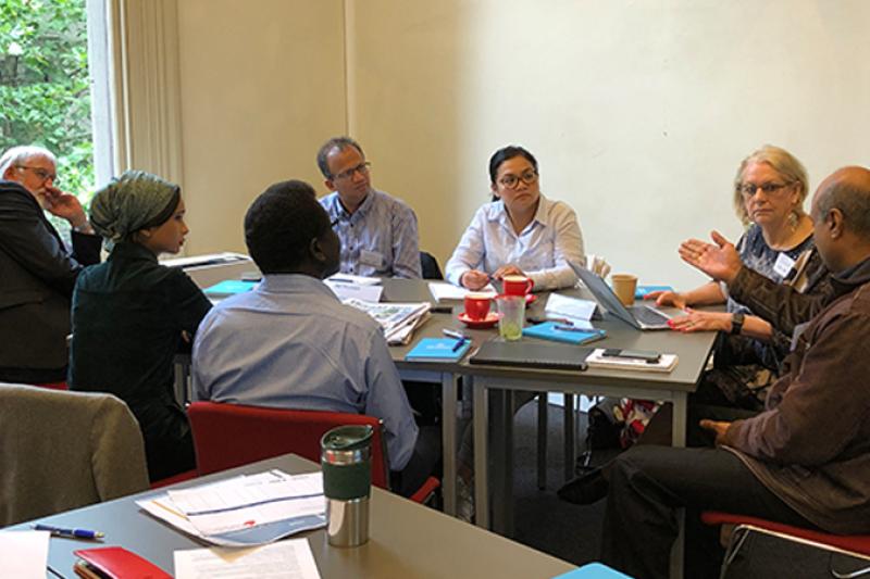  Photo of the program participants sitting at a table discussing 