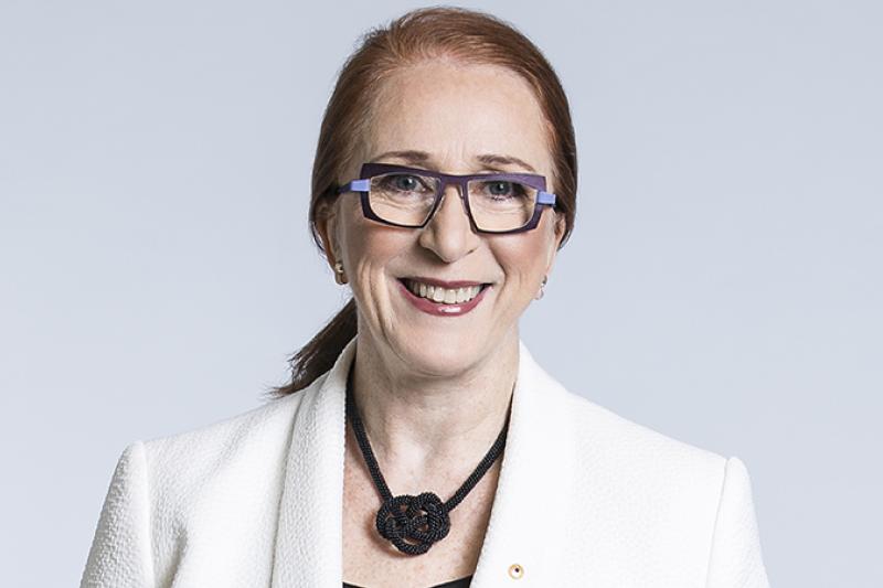 Emiritus Professer Rosalind Croucher, wearing white jacket, smiles at the camera