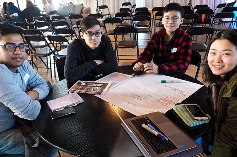 Four university students of diverse background with paper project plans