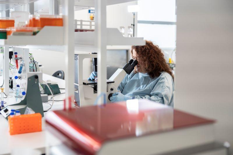 Vasso Apostolopoulos in a lab, looking through a microscope
