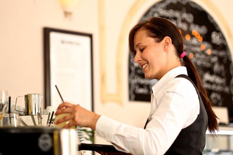 Female cafe worker making coffee