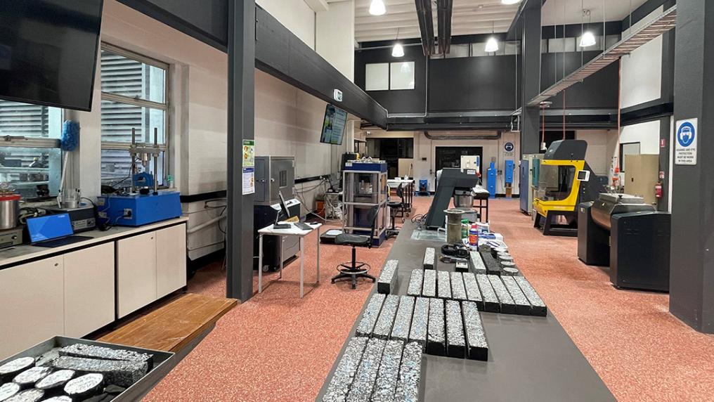 A large laboratory with rectangles of asphalt and testing equipment