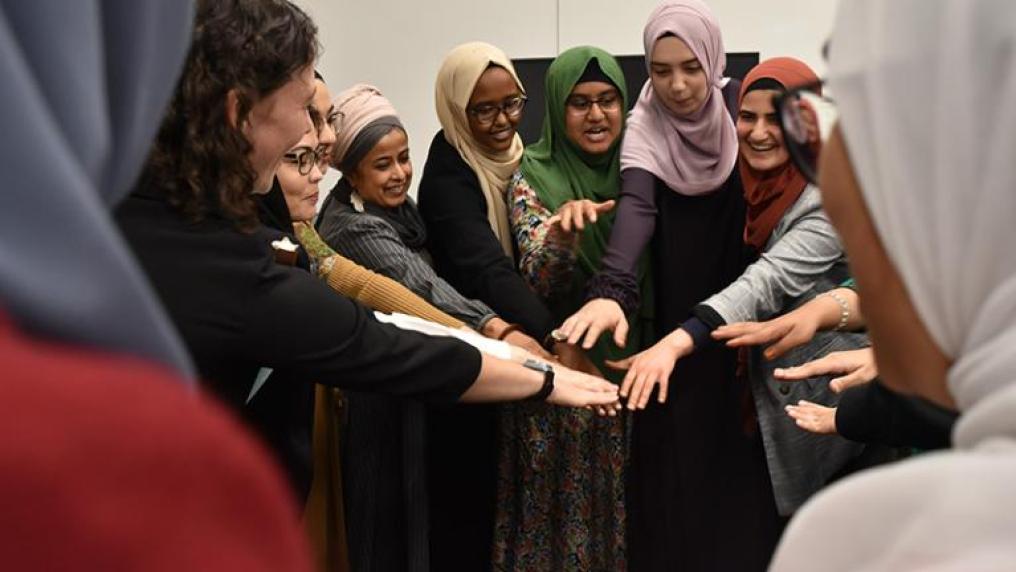 Photo of a program participants celebrating in a group circle