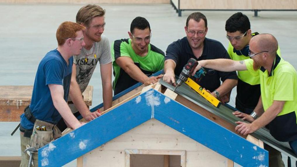 Construction students at Sunshine Construction Hub making a dog house.