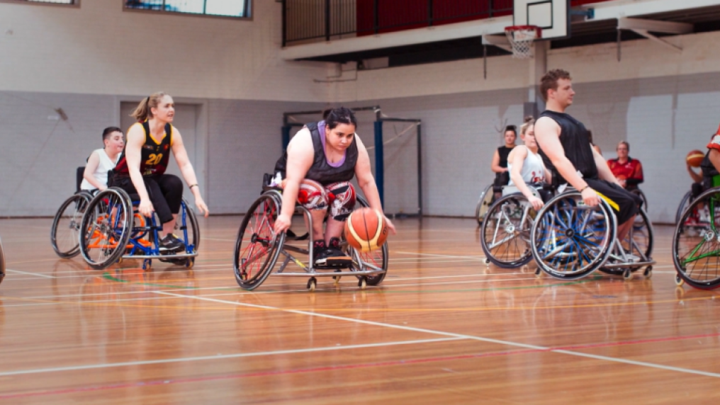 female athlete playing wheelchair basketball