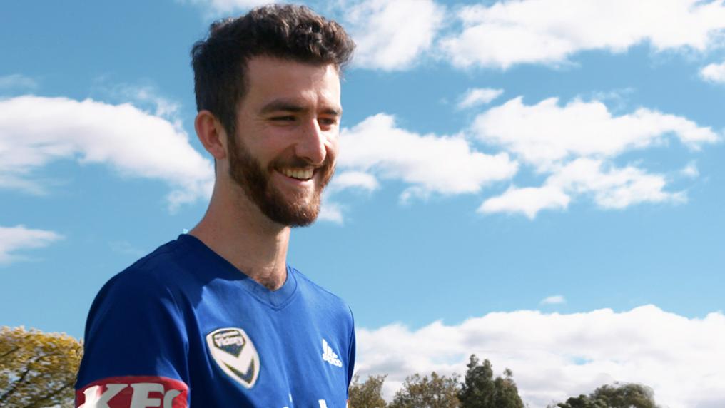 Samuel Dunn smiling outside in a soccer top