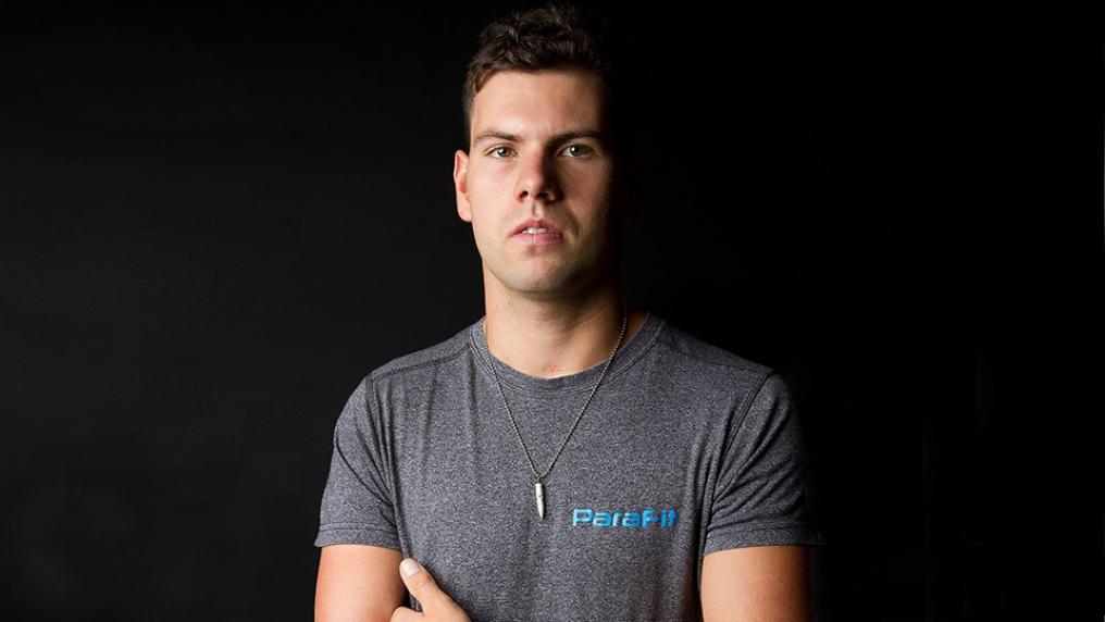 Tommy Quick, Bachelor of Human Nutrition graduate standing in front of black background