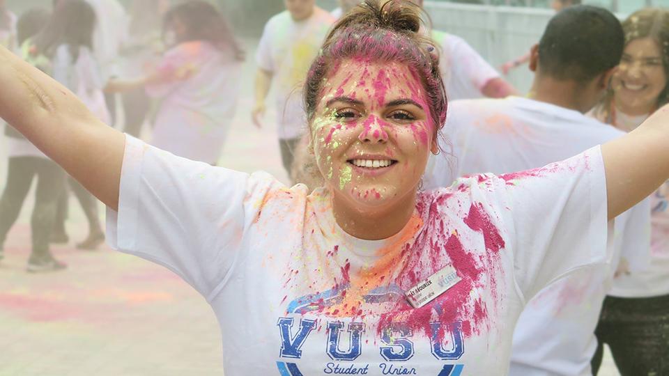 Catherine Abourizk in a VUSU T-shirt with paint on it and on her face and hair