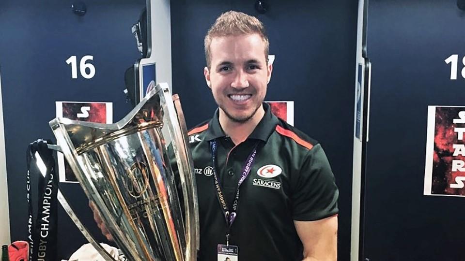 Eoin McVeigh smiling and holding a giant trophy