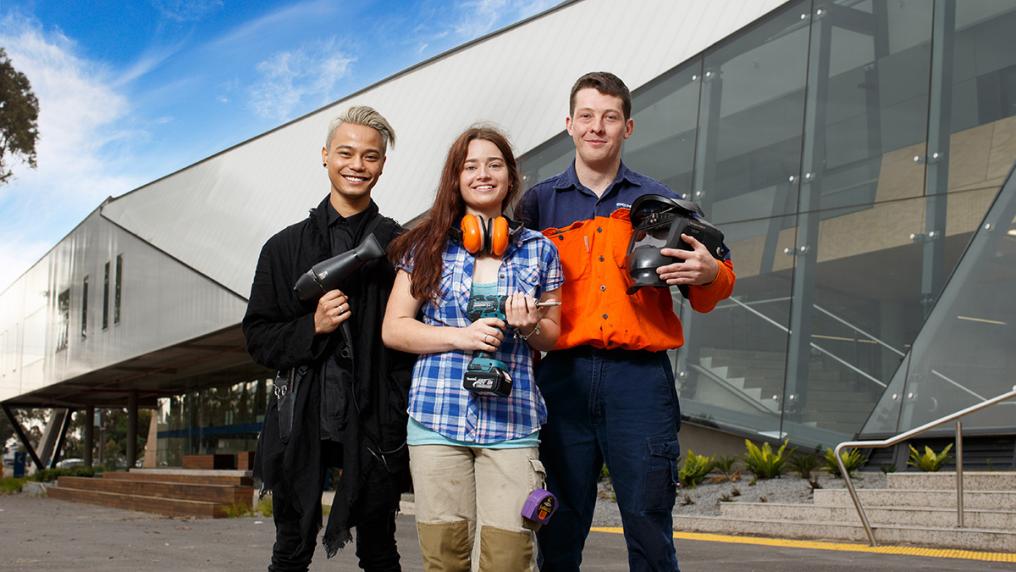 a young, hip, male hairdresser; young woman holding a drill; young man in workers uniform holding welding mask