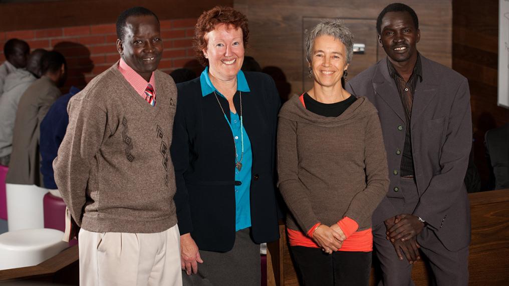 Two middle-aged African men in suits with 2 white female teachers