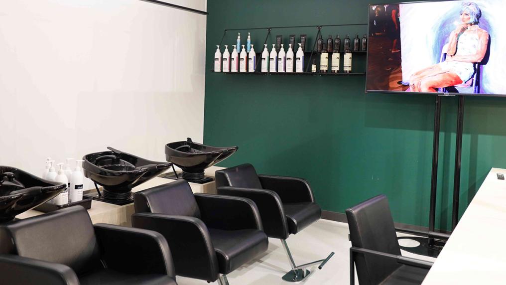 Modern salon with large screen and hairdressing chairs