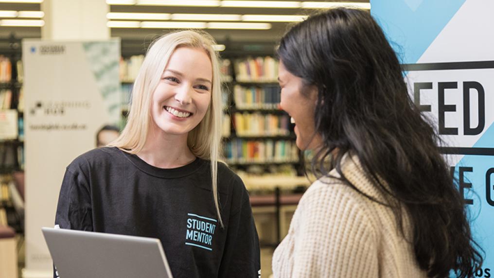 A Learning Hub stuent mentor smiles at a student.