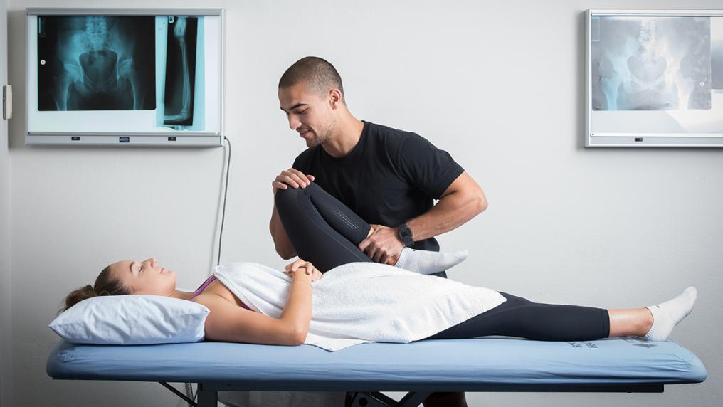 An osteopathy student works with a client.