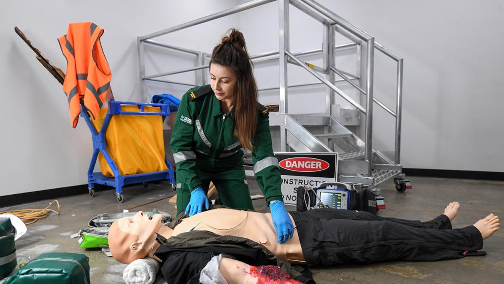 A paramedicine student practices on a dummy.