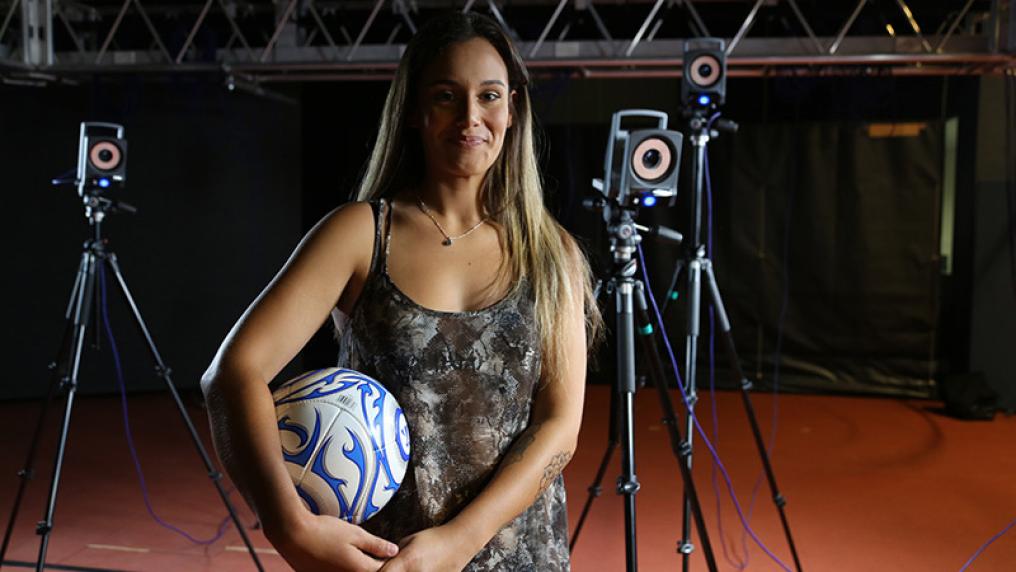 female teaching student posing with a volleyball in hand