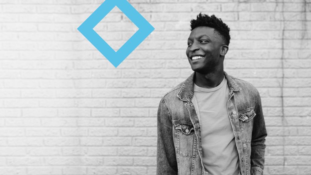 A student stands next to the VU blue branded diamond.