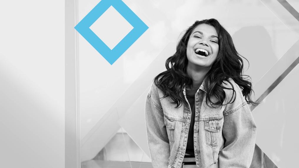 A laughing student stands next to the VU blue branded diamond.