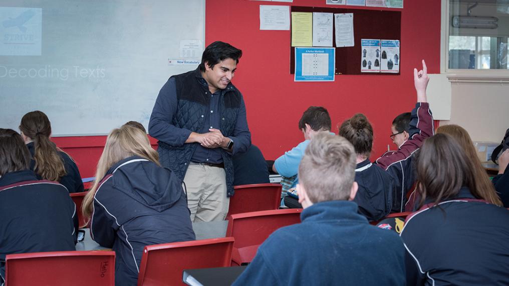 Teacher in front of a class of teens in uniform