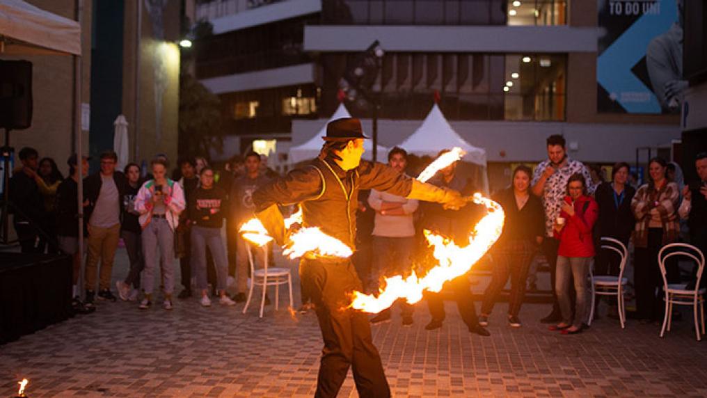 A fire twirler performs at O-Fest Block Party.