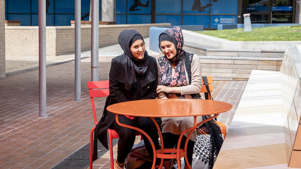 Zahra and Fatemeh Sayahi sitting outside at Victoria University's campus.