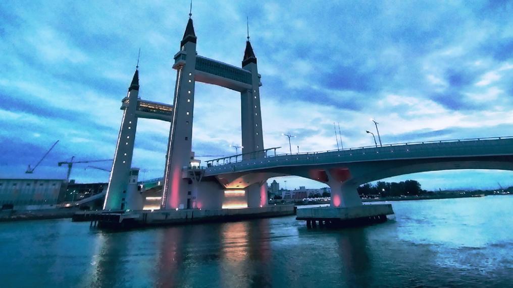 A bridge with two large towers surrounding it. A cloudy, low-light day.