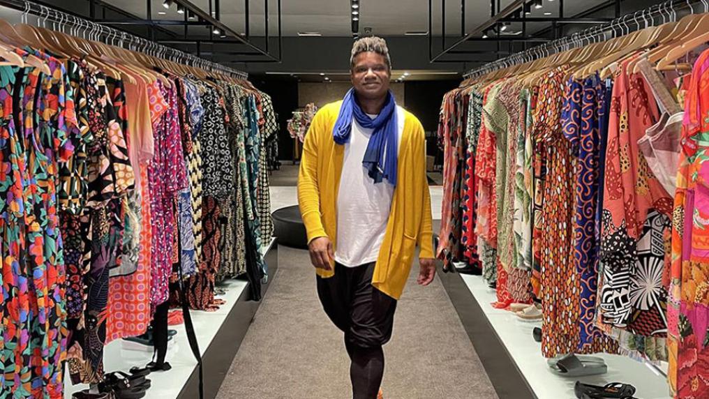 Guido Melo between aisles of clothes