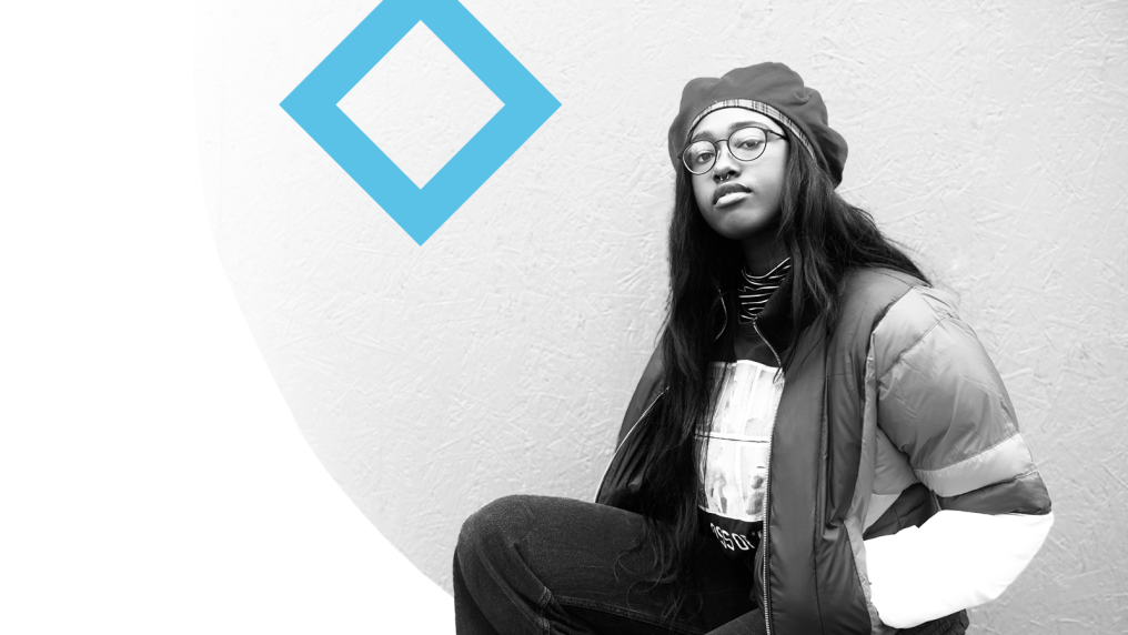 A student sits next to the VU blue branded diamond.
