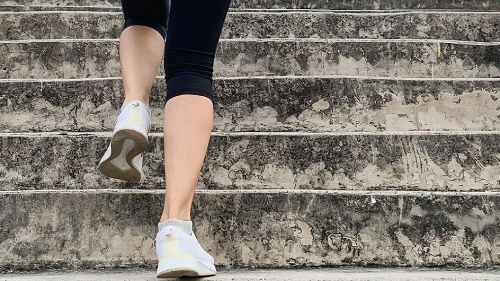 Person in sports shoes walking up steps