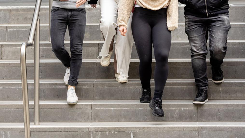 Four students walk down stairs.