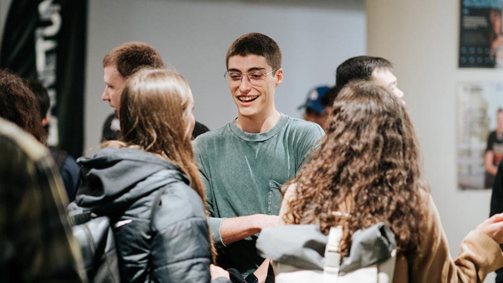 A group of students smile and chat
