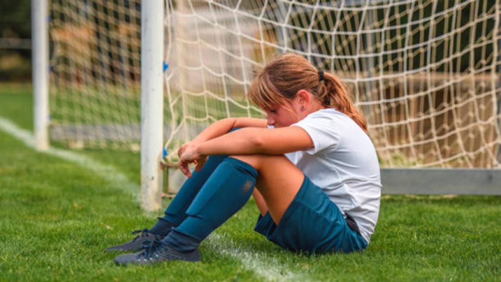 Child looking sad on soccer pitch