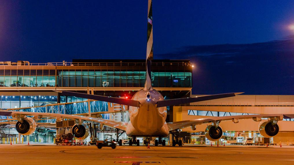 An large modern airport at night with a plane in the foreground