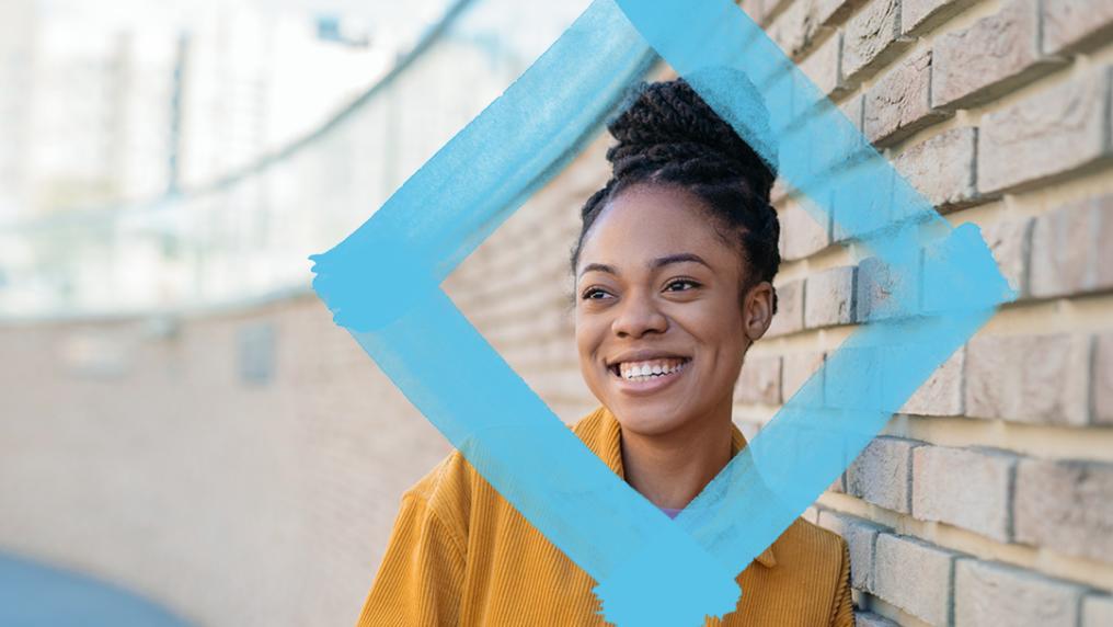 Student leaning against wall with VU blue branded diamond.